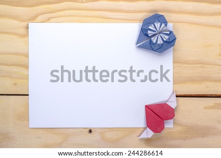 two origami hearts and white paper sheet for love message.