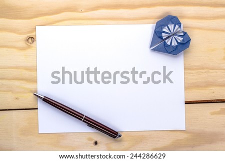 valentine letter with origami blue heart on wooden table