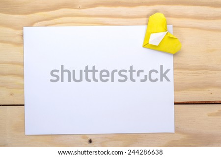 yellow origami heart and white paper sheet for romantic letter.