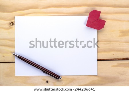 valentine letter with origami red heart on wooden table