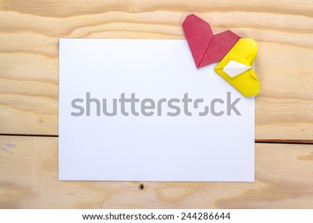 valentine letter with origami blue and yellow hearts on wooden table