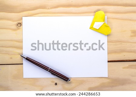 valentine letter with origami yellow heart on wooden table