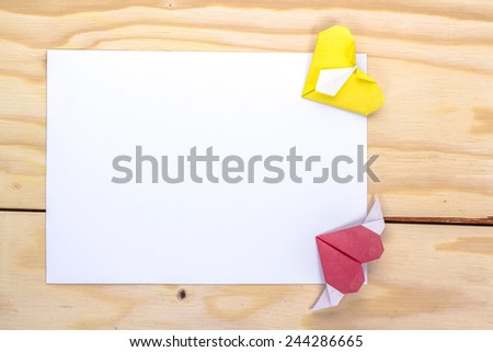 valentine letter with origami red and yellow hearts on wooden table