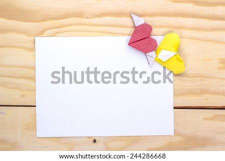 love letter with origami red and yellow hearts on wooden table