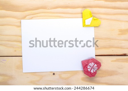 valentine massage with origami red and yellow hearts on wooden table