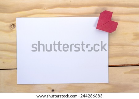 valentine massage with origami red heart on wooden table