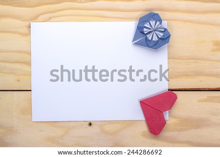 love letter with origami red and blue hearts on wooden table
