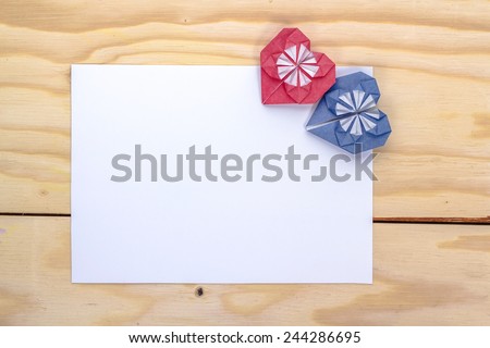 valentine massage with origami red and blue hearts on wooden table