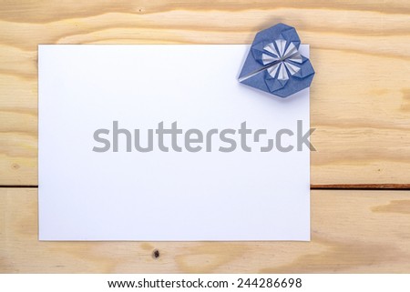 valentine letter with origami blue heart on wooden table