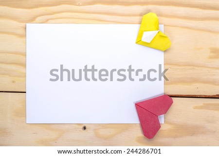 valentine letter with origami red and yellow hearts on wooden table