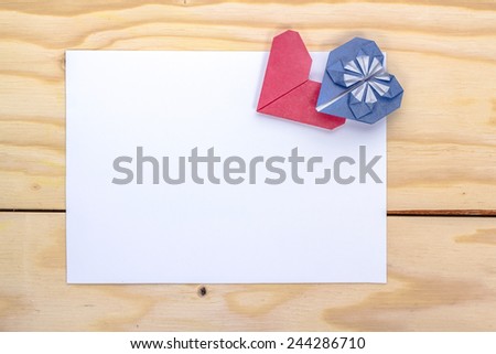 valentine letter with origami blue and red hearts on wooden table