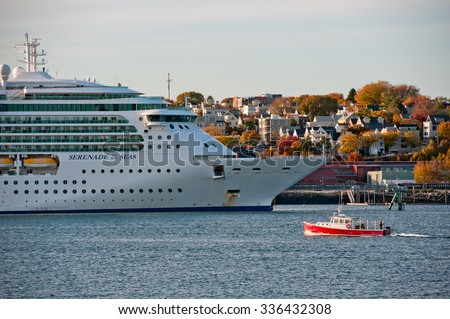 PORTLAND, MAINE - OCTOBER 27, 2015 - Princess Cruise Lines the Serenade of the Seas cruise ship dwarfs a local lobster boat in Portland, Maine.