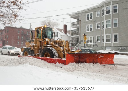 PORTLAND, MAINE, USA - DECEMBER 29, 2015: Snow plow clearing the street in Portland, Maine during a snowstorm. The December 29th storm was the first storm of the unusually warm winter season.