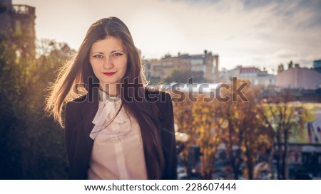 Fashion elegant stylish woman posing on streets of European city in autumn evening weather. Sensual brunette vogue girl street style portrait