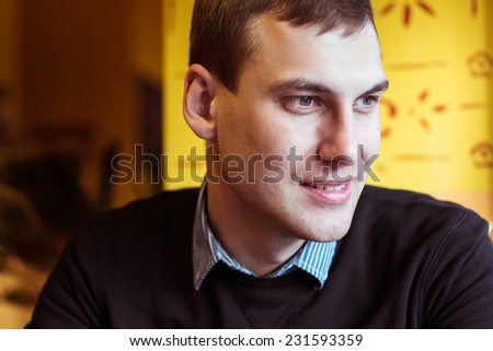 young attractive man looking and thinking. portrait of handsome man sitting in cafe