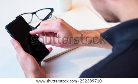 Man using a cell phone on cafe terrace and drink coffee