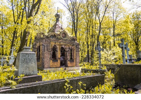 Cemetery in autumn. Autumn cemetery with crosses and the old crypt. Autumn leaves, the crosses on the graves, the old building that is a crypt.