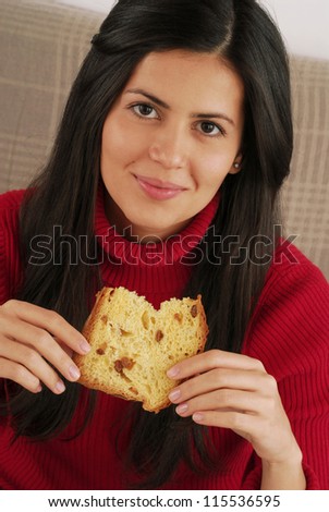 Beautiful young woman eating sweet christmas bread.Woman eating panetone.