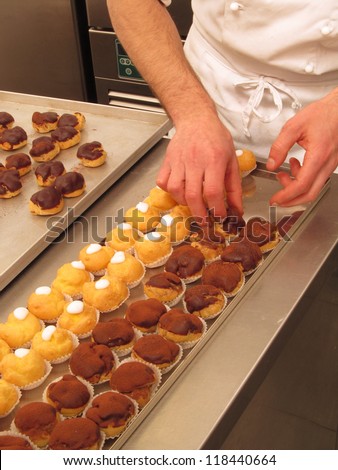 Chef preparing and organizing cupcakes.