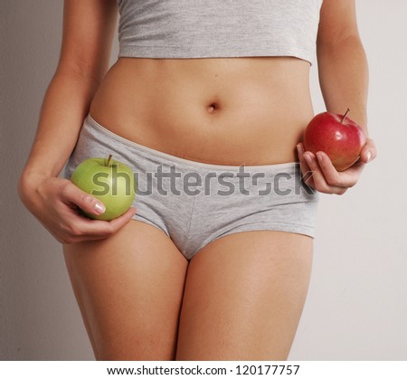 Young woman body detail holding two apples.