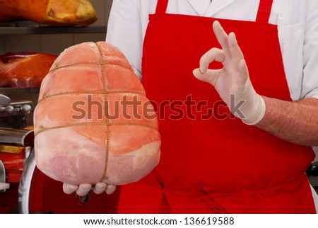 Butcher holding traditional prosciutto ham,