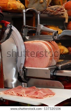 Ham slicer and prosciutto ham in a warehouse.