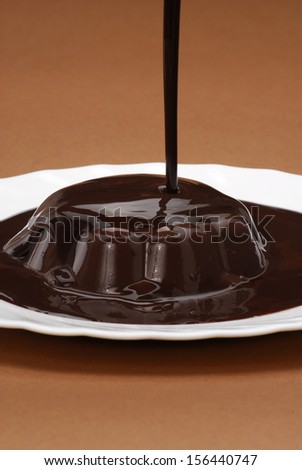 Pouring chocolate on chocolate pudding.