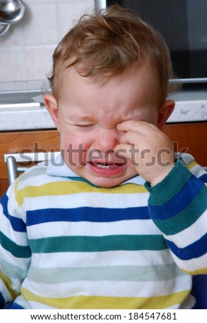 Crying baby in the kitchen.Crying child.Little child crying.