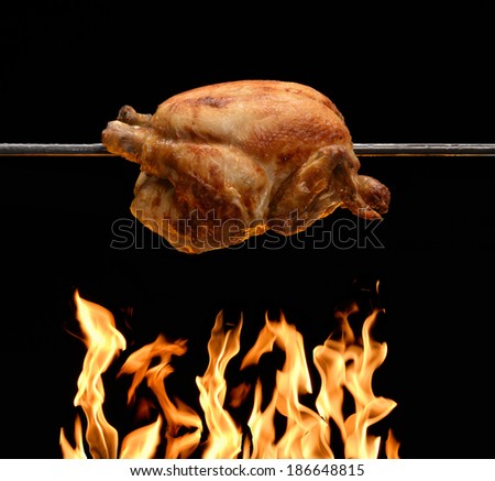 roasted chicken on barbecue grill flame