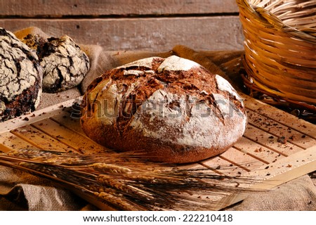 Rustic bread and wheat on an old vintage planked wood table and chest.