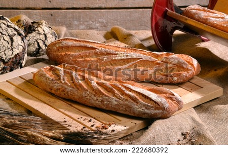 Rustic bread and wheat on an old vintage  wood table and chest.