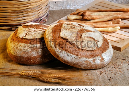 Rustic bread and wheat on an old vintage wood table and chest.