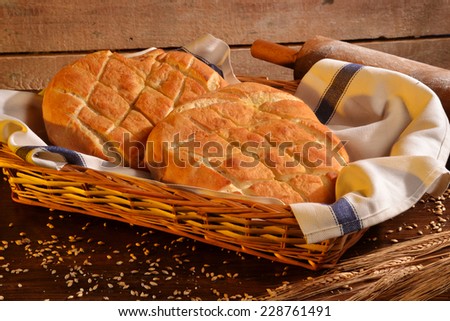 Foccacia Italian bread on rustic wood table and ingredients.Rustic bread and corn on an old vintage wood table.