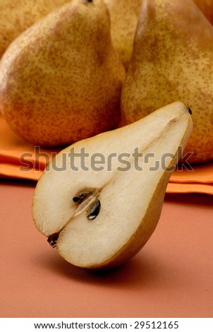 Group uf pears on orange background.Detail of a cut pear.Half pear