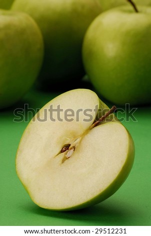 Still life with severalgreen apples and half apple.