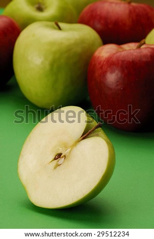 Still life with several types of apples and half apple.