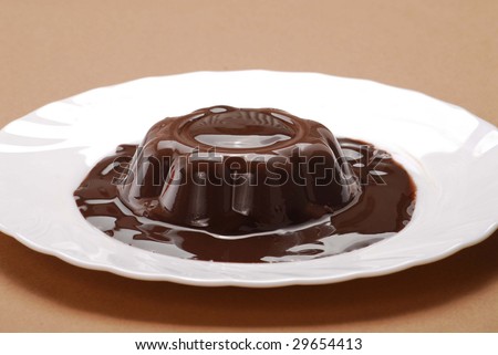 Chocolate pudding on dish.Chocolate flan on dish. Flowing chocolate over pudding.