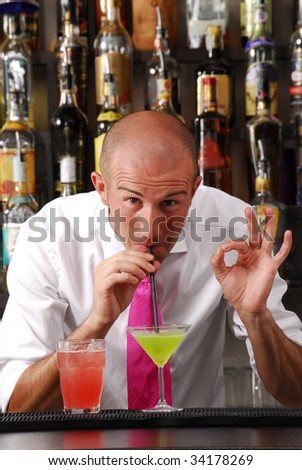 Bartender drinking cocktail. Barkeeper tasting cocktail. Bartender and cocktails.