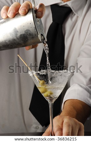 Hands pouring a martini cocktail. Bartender pouring liquor, Barman pouring a drink. Bartender pouring Martini.