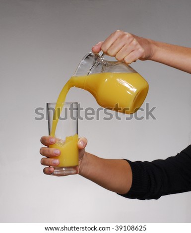 Pouring orange juice into glass. Orange juice glass jar.