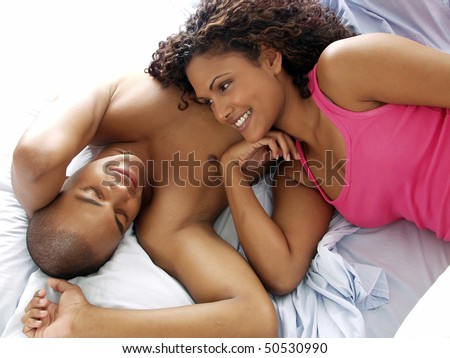 Happy afro american couple on bed. Latin couple on bed.