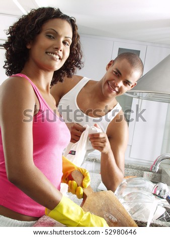 Afro american couple washing up dishes. Latin couple washing up dishes.
