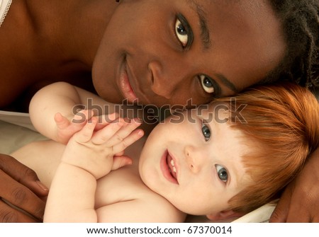 Afro American woman hugging a caucasian child. Racial diversity.