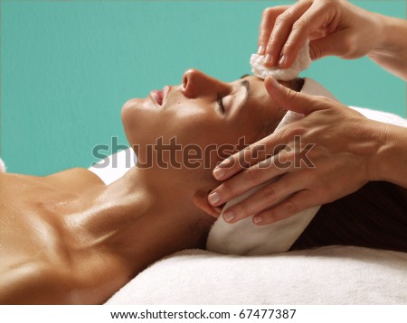 Beautiful young woman getting a face treatment at beauty salon.