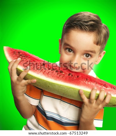 Funny and happy little boy eating watermelon.Little boy holding a big watermelon.