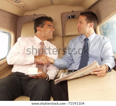 Business man shaking hands and working at private jet.