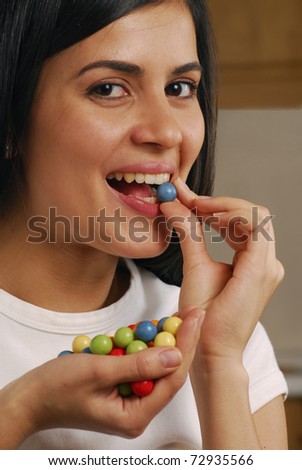 Young woman eating candies.
