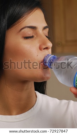 Young woman drinking mineral water. Young woman drinking water from bottle.