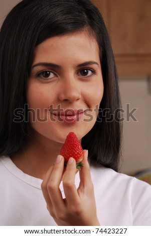 Young woman eating fresh strawberries,