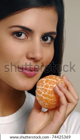 Young woman holding a fresh peeled tangerine.